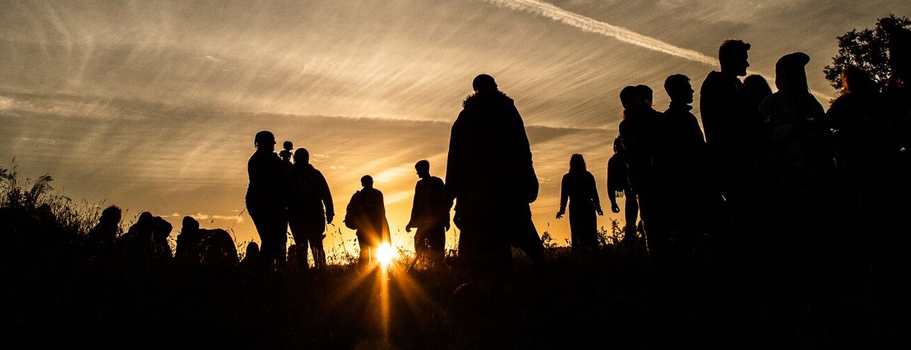 worshippers silhouetted by the rising sun at avebury on solstice morning