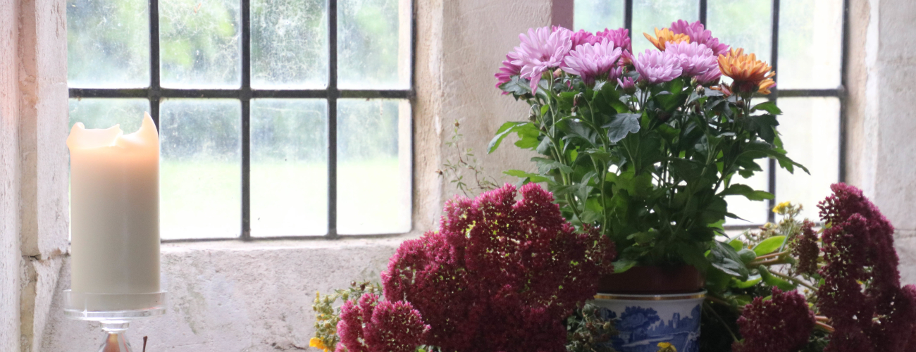 candle and flowers in window of WInterbourne monkton