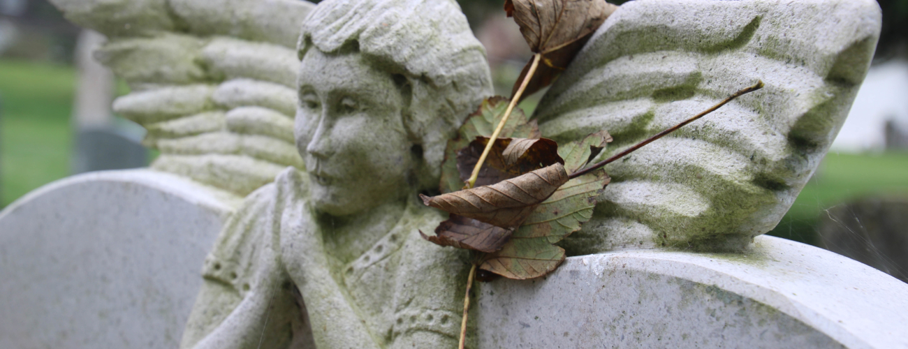 part of a headstone showing an angel carving